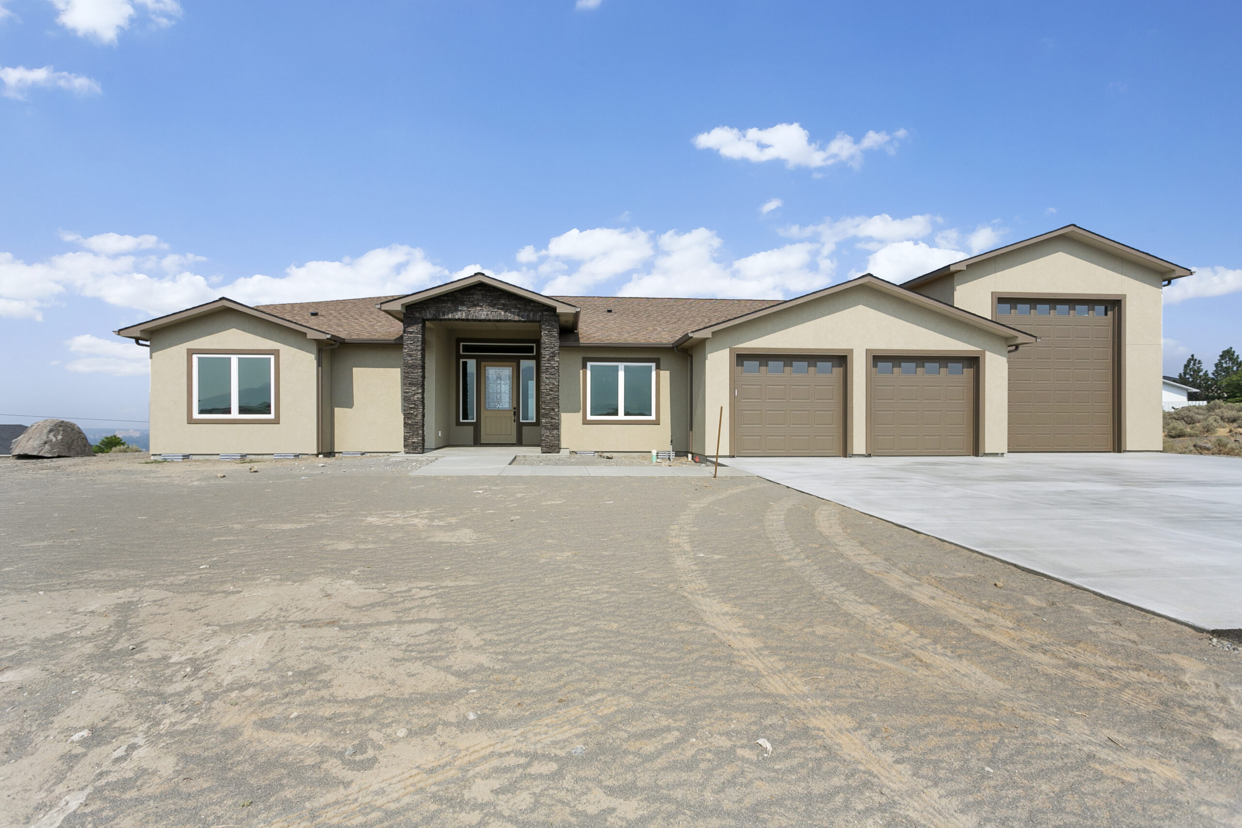 Front view of a modern home with garage, walkway and front yard.