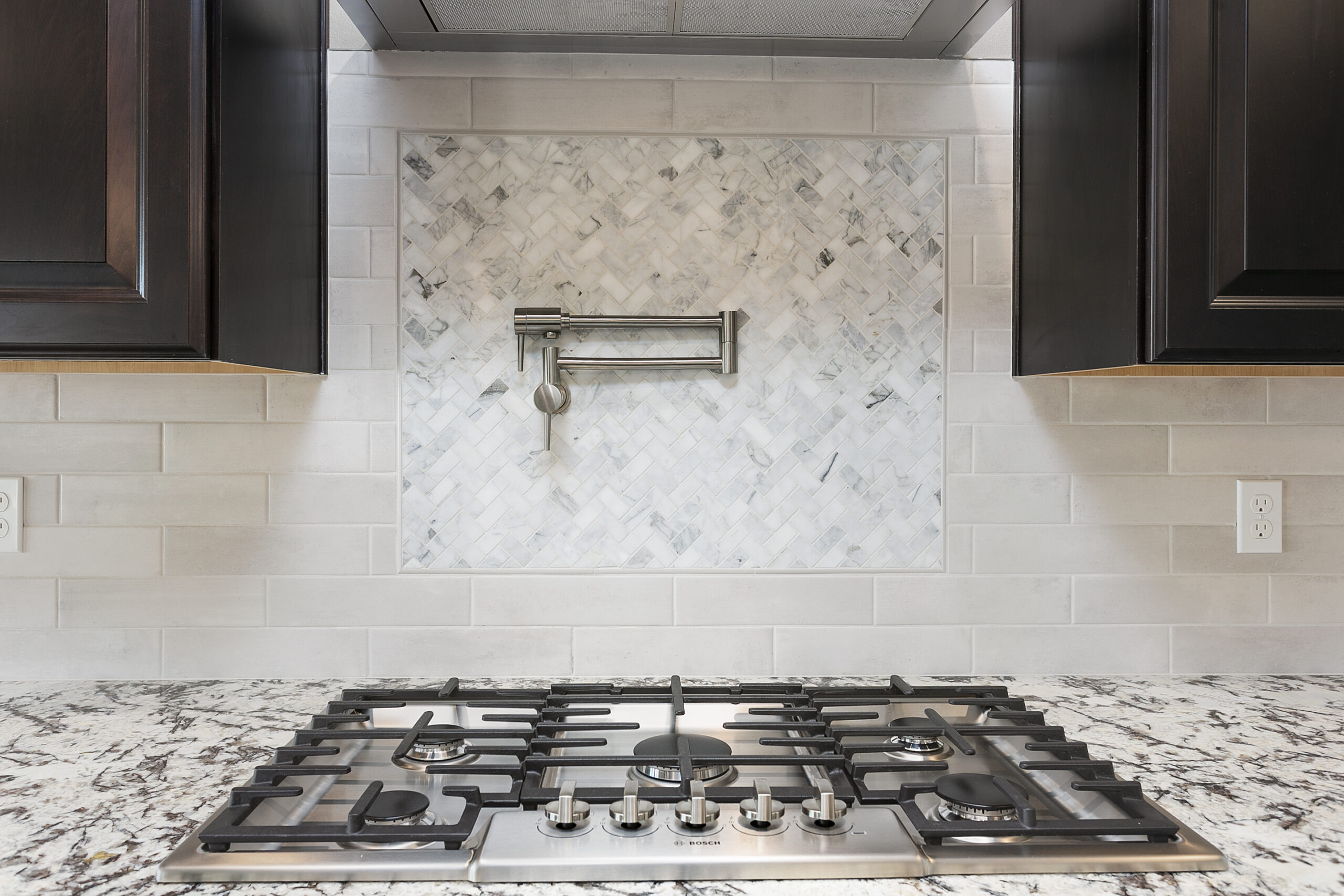 Modern Cooktop with backsplash and water faucet.
