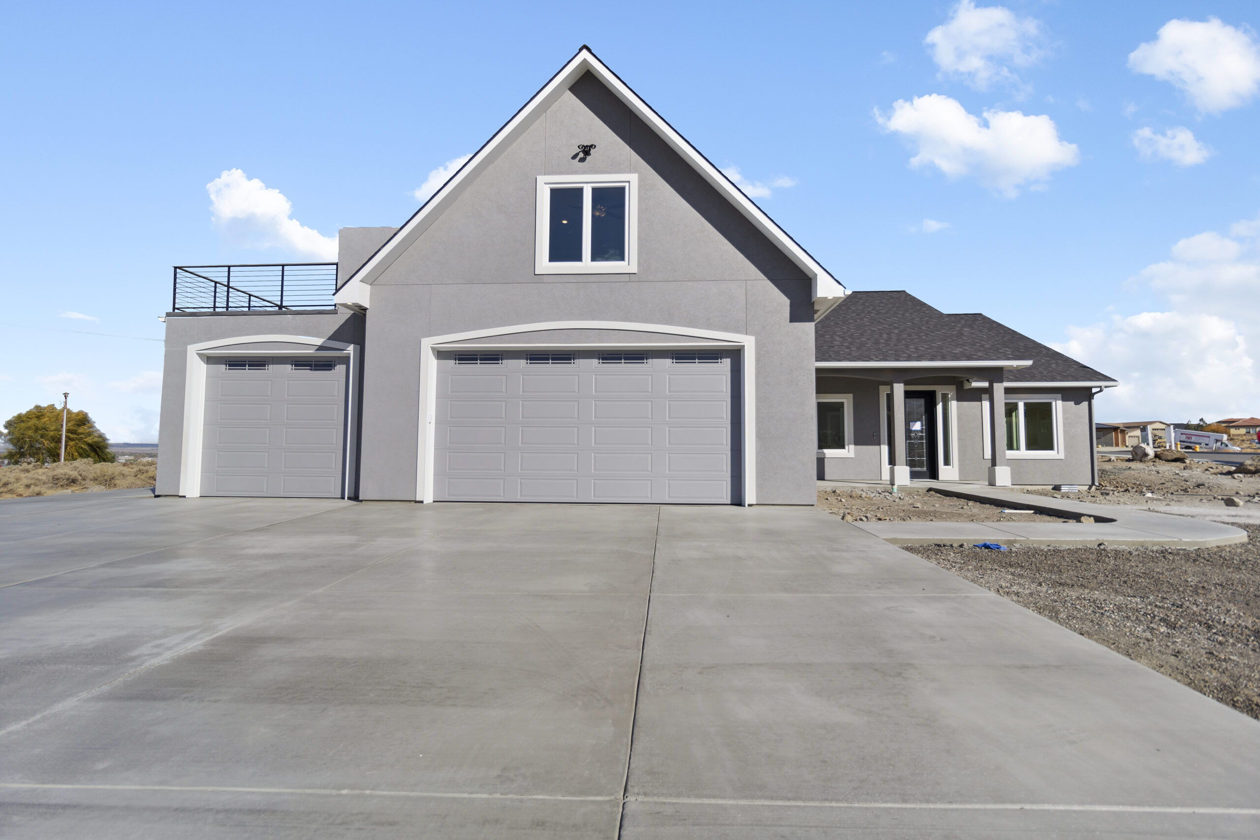 Front view of a modern home featuring garage, walkway, driveway and front yard.